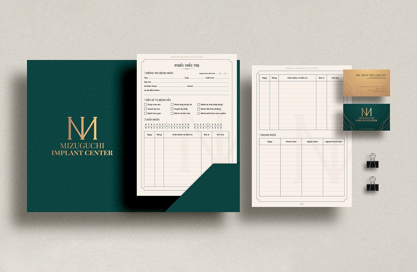 Dental clinic branded stationery in dark green with a gold monogram
